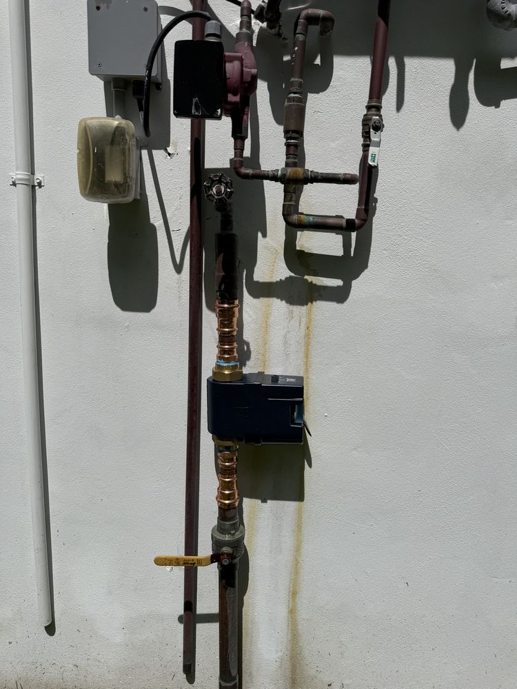 Outdoor Plumbing Pipes and Valves on a White Wall